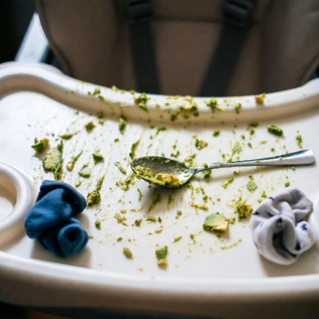 Avocado chaos on highchair tray.